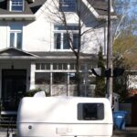 a white trailer parked in front of a white house